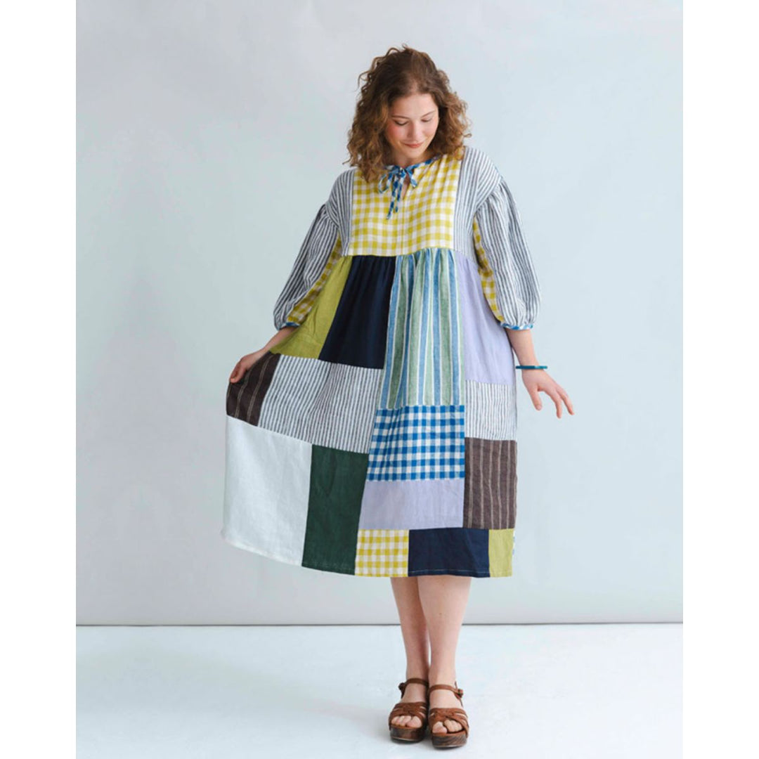 Woman wearing a patchwork dress with a white background