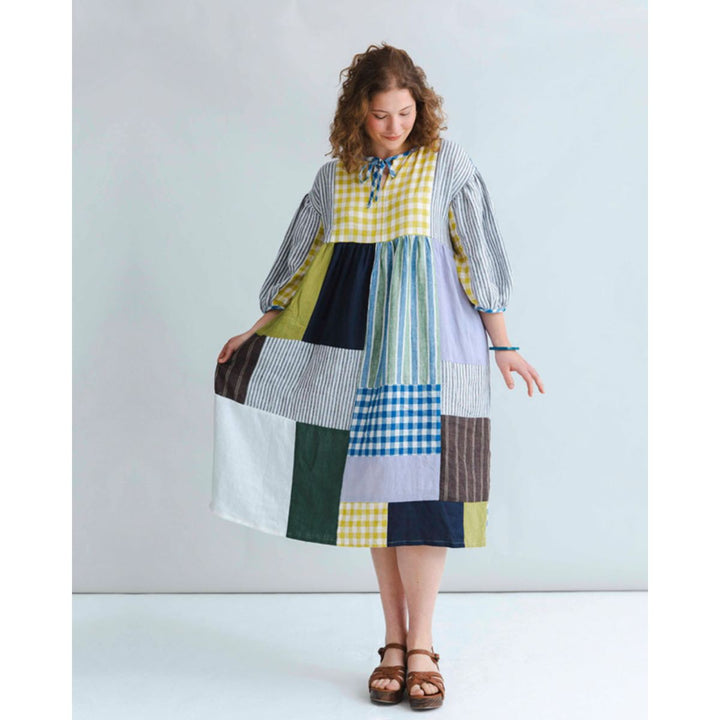 Woman wearing a patchwork dress with a white background