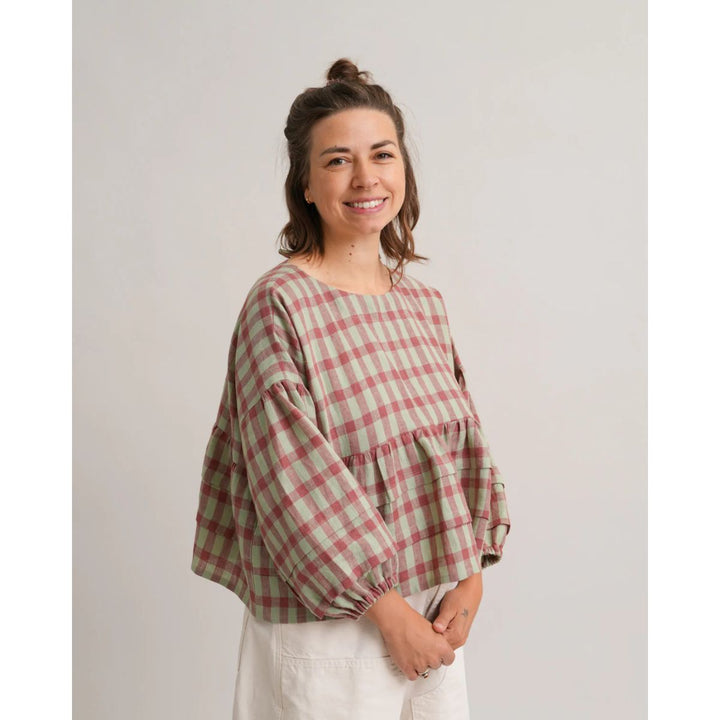 Woman wearing a plaid shirt against a plain background