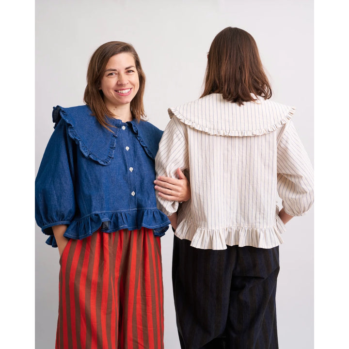 Two women wearing different outfits with ruffled collars against a white background