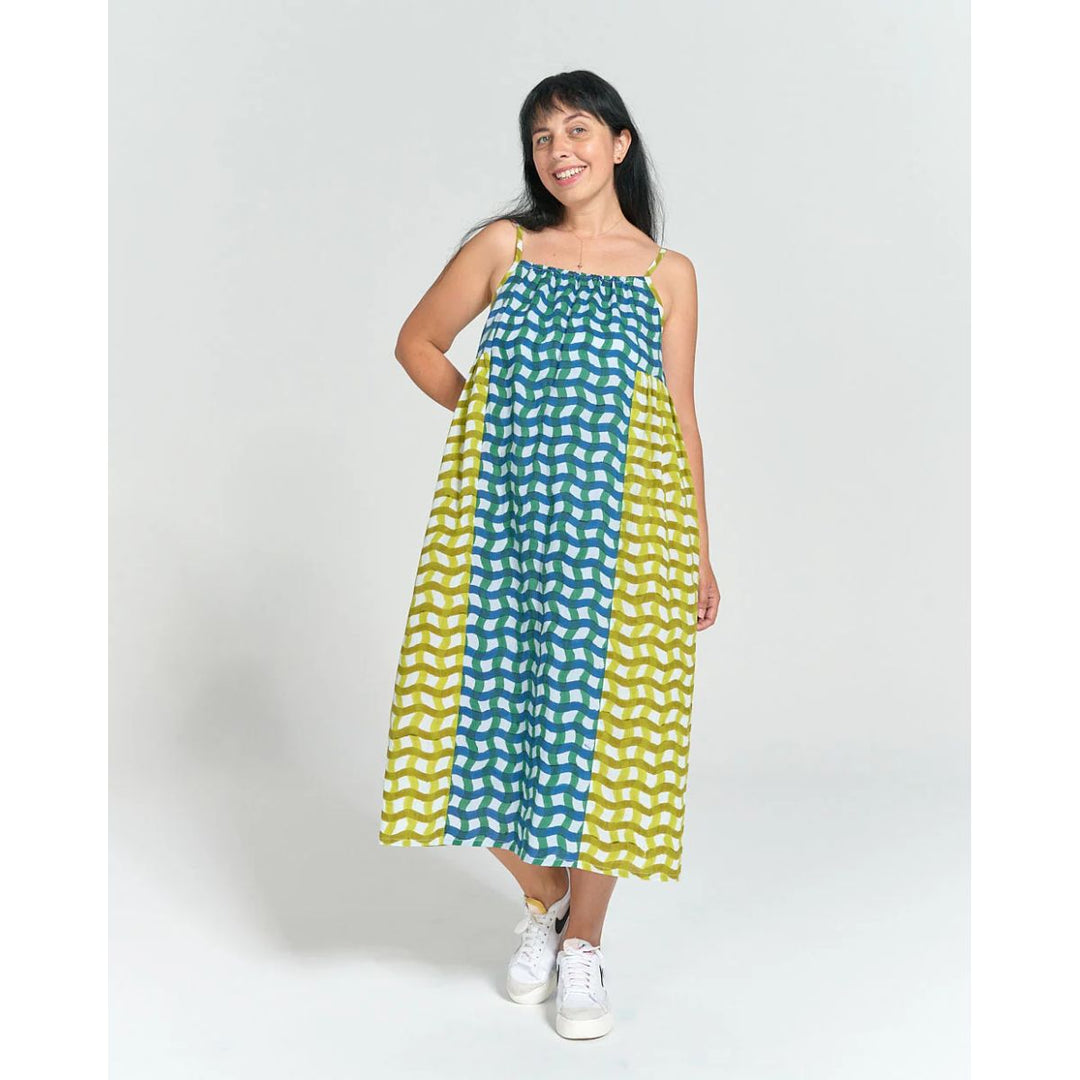 Woman wearing a green and yellow patterned dress on a white background