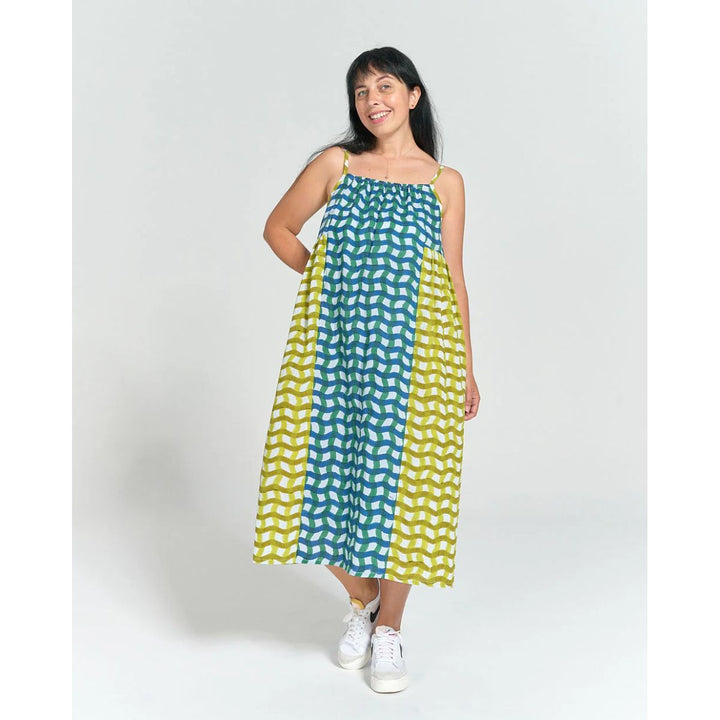 Woman wearing a green and yellow patterned dress on a white background