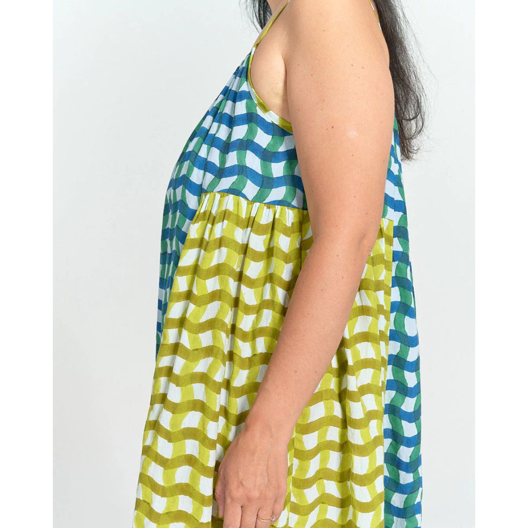Woman wearing a sleeveless dress with a geometric pattern on a white background