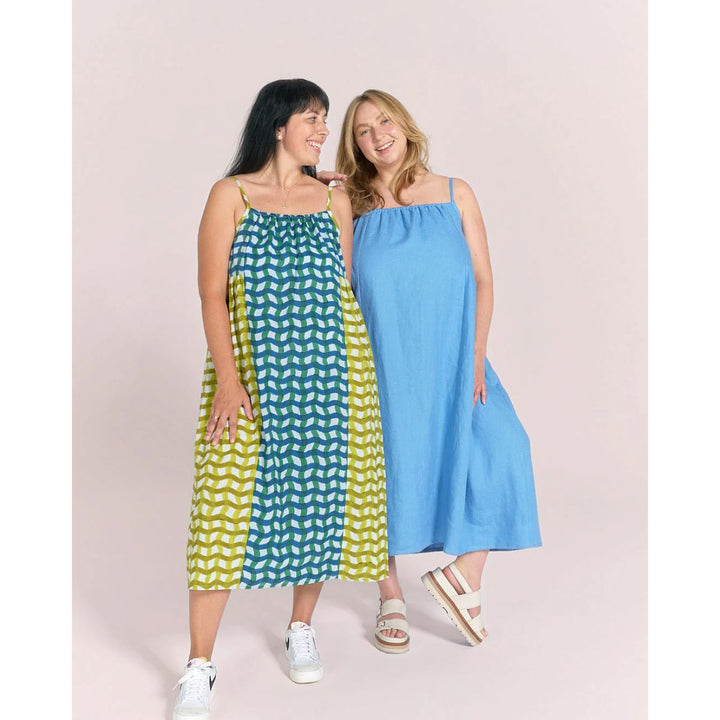 Two women wearing sleeveless dresses against a plain background