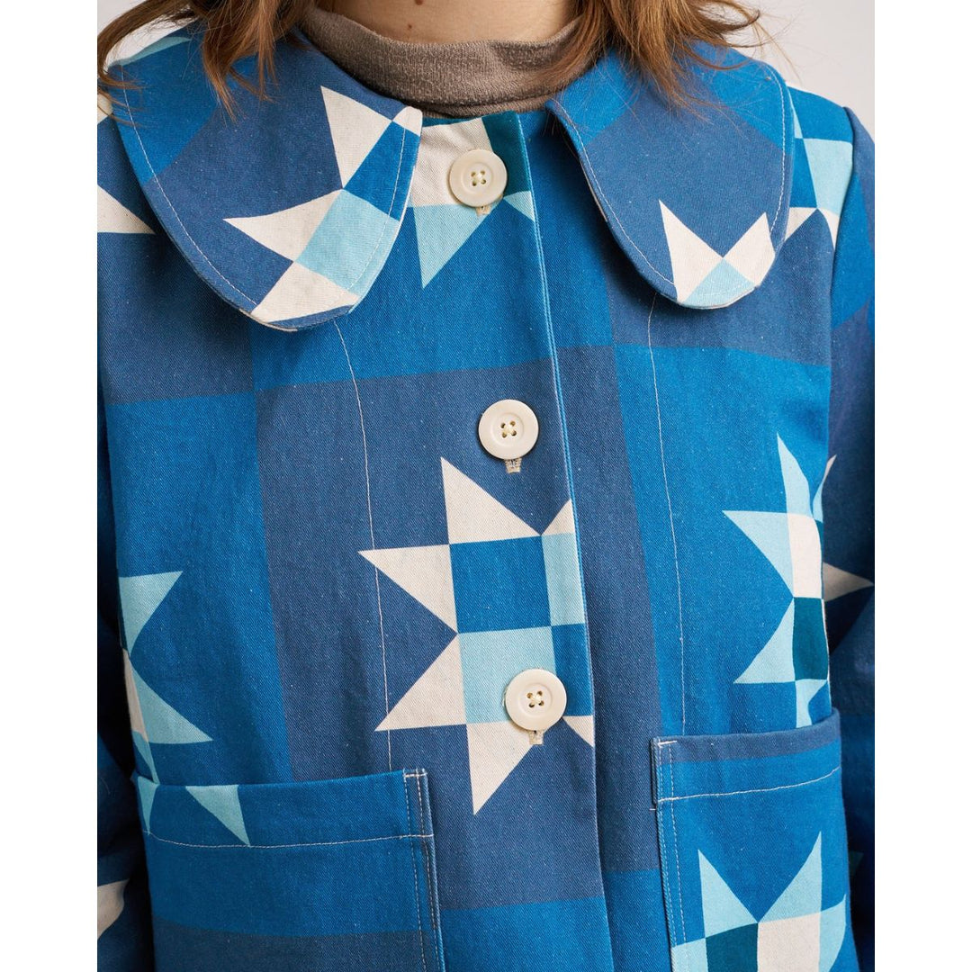 Blue coat with star pattern and buttons on a white background