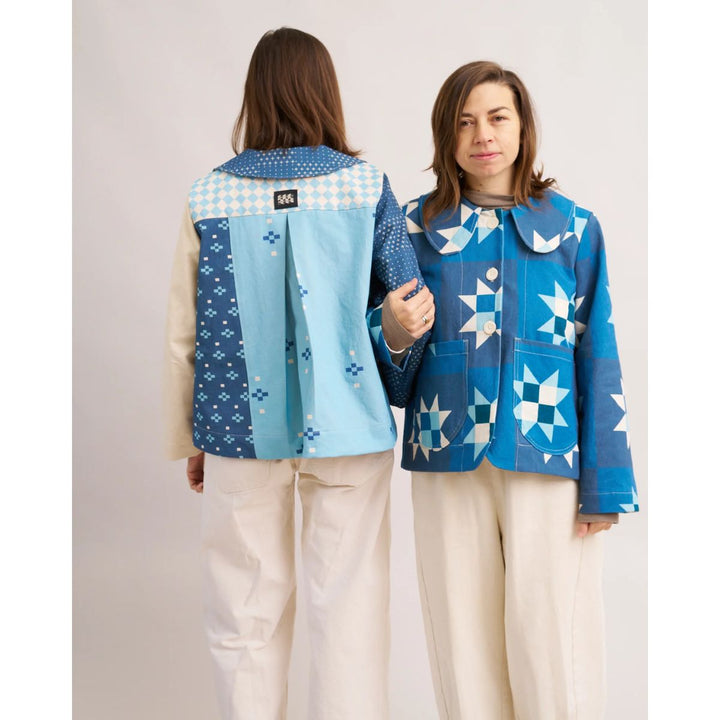Two people wearing blue patterned jackets on a plain background