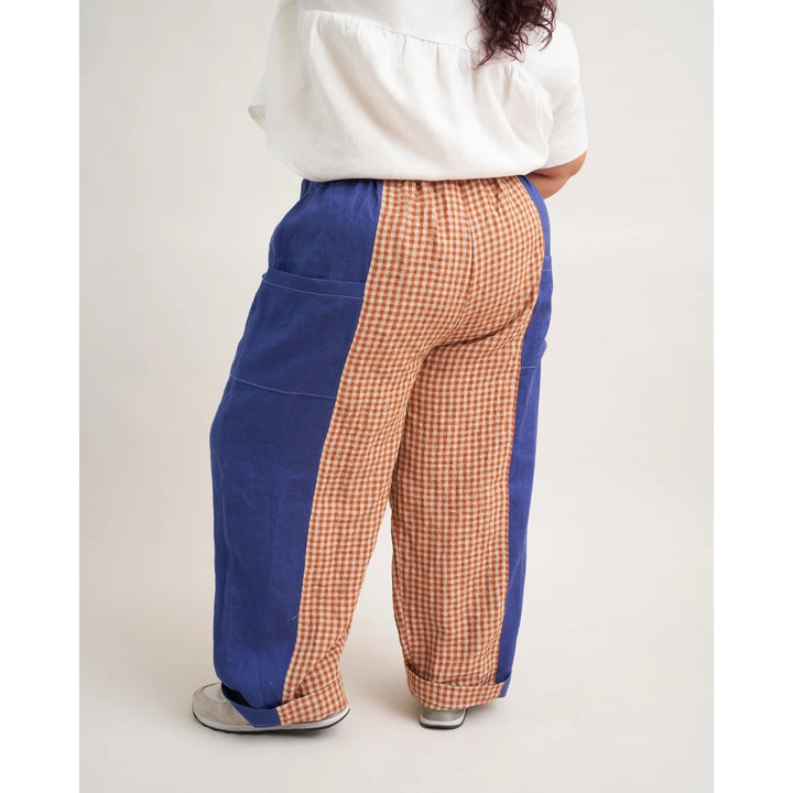 Pants with blue and checkered patterns worn by a person on a white background