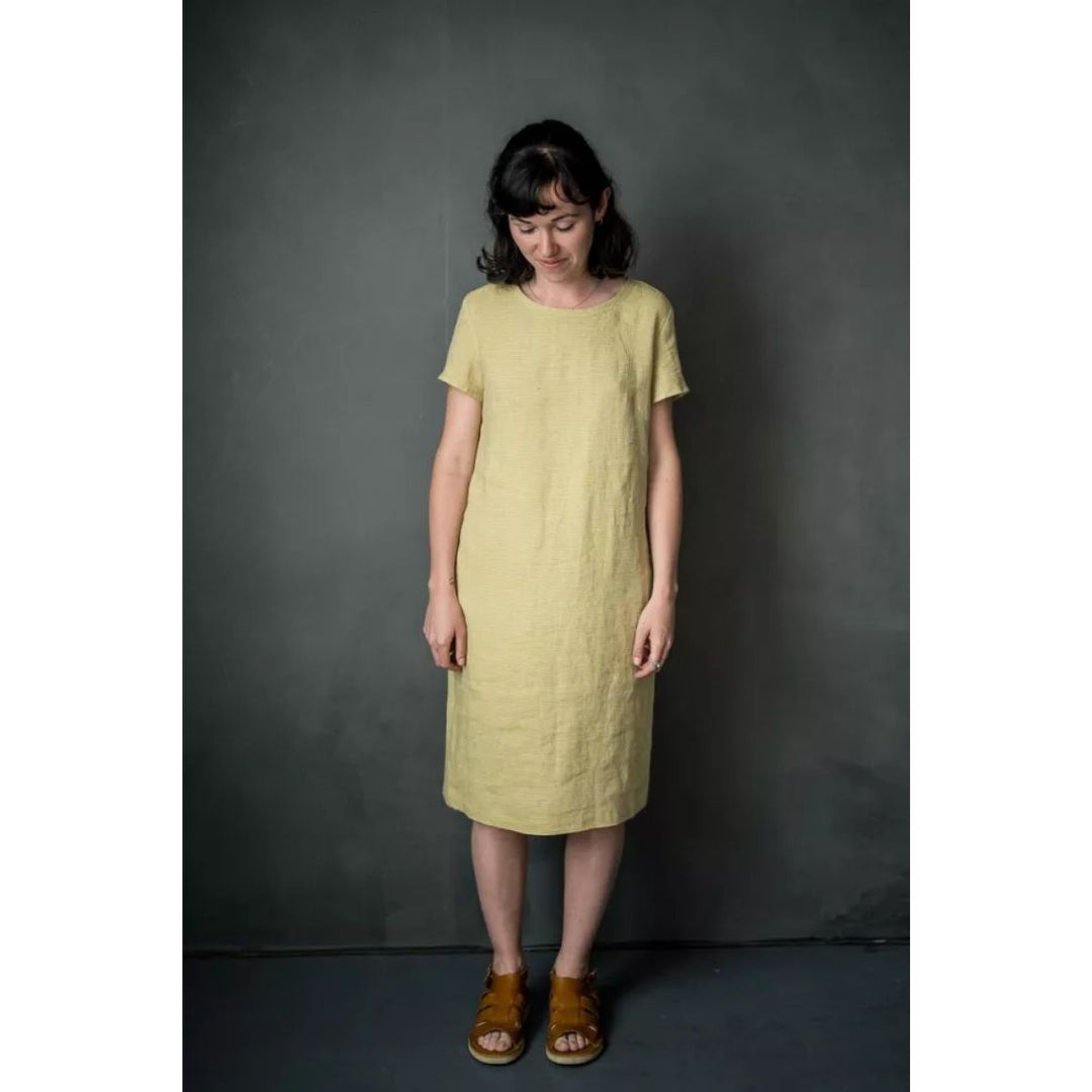 Woman wearing a light green dress against a dark gray background