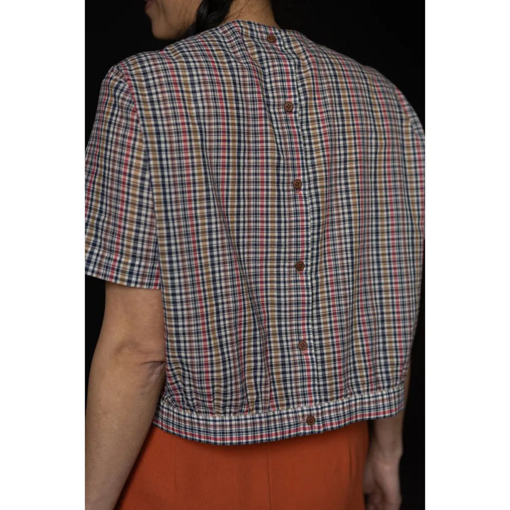 Person wearing a plaid shirt with a black background