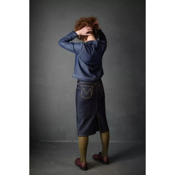 Person wearing a blue denim outfit against a gray background