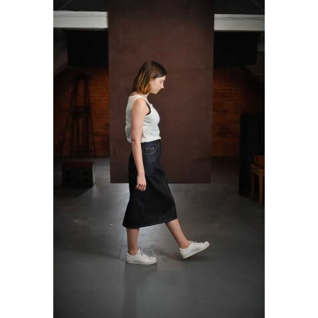 Woman walking in a dark room with a brick wall.
