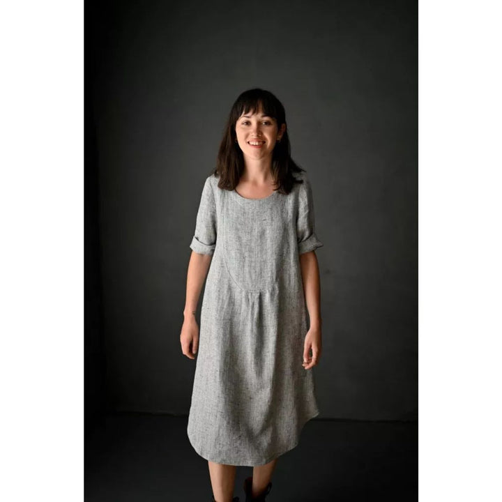 Woman wearing a gray dress against a dark background