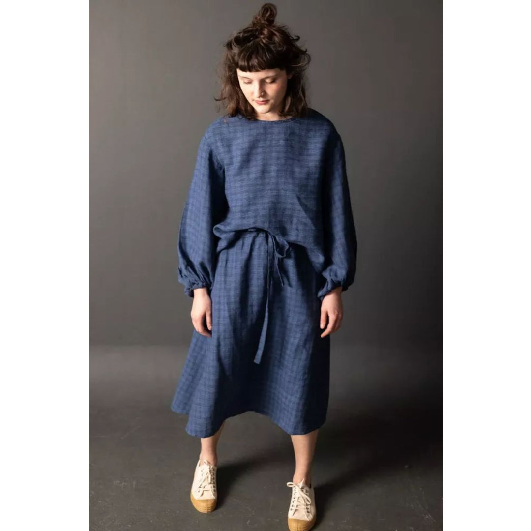 Woman wearing a blue dress against a gray background