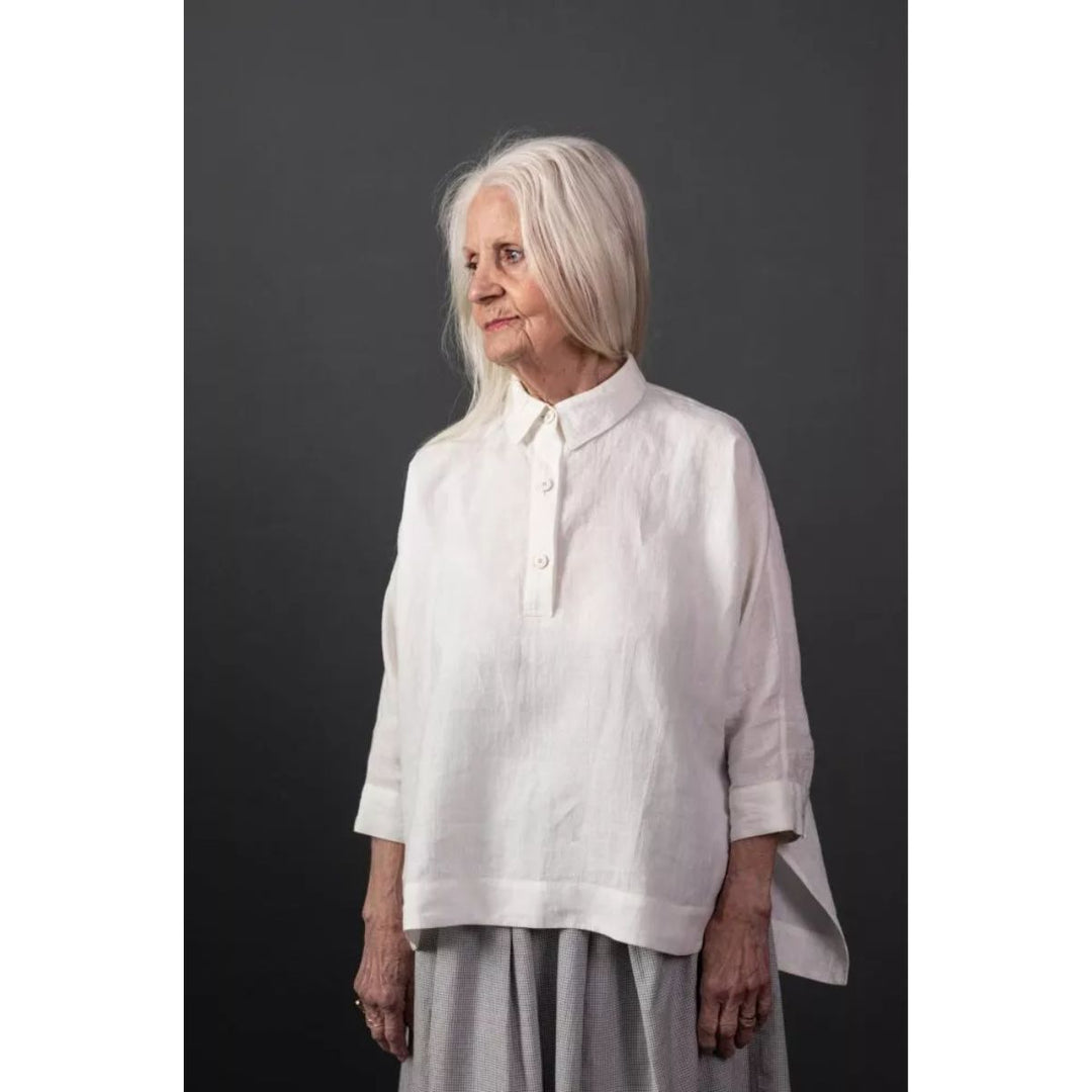 Woman wearing a white shirt against a dark background