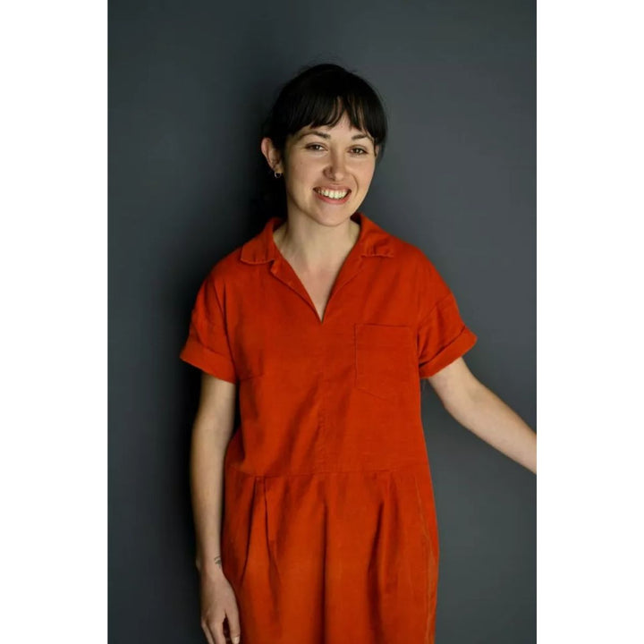 Woman wearing an orange dress against a dark background