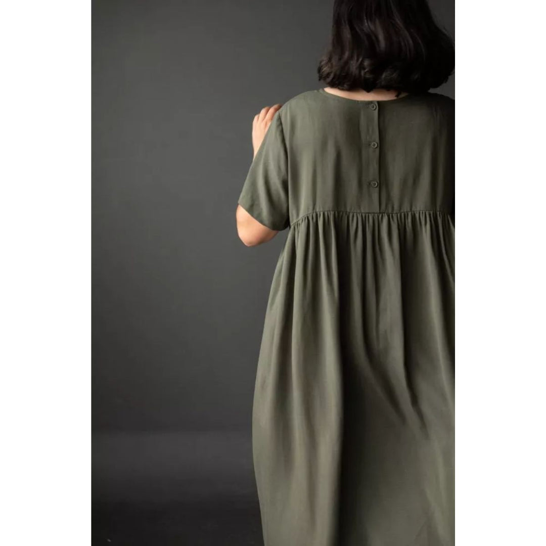 Person wearing a green dress against a dark background