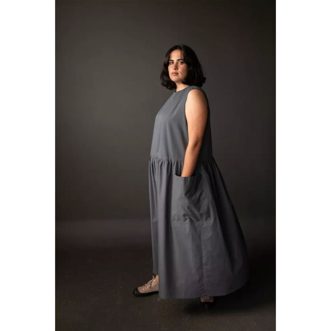 Woman wearing a gray dress against a dark background