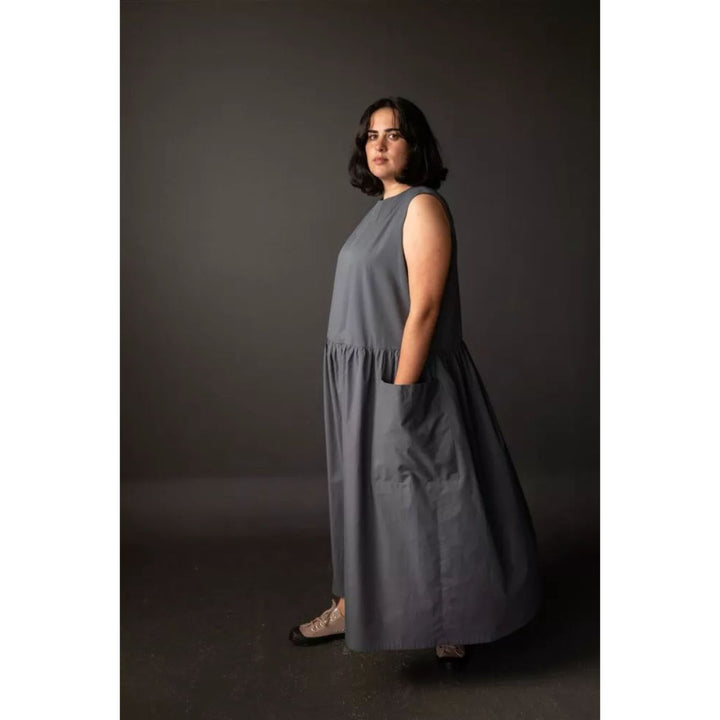 Woman wearing a gray dress against a dark background