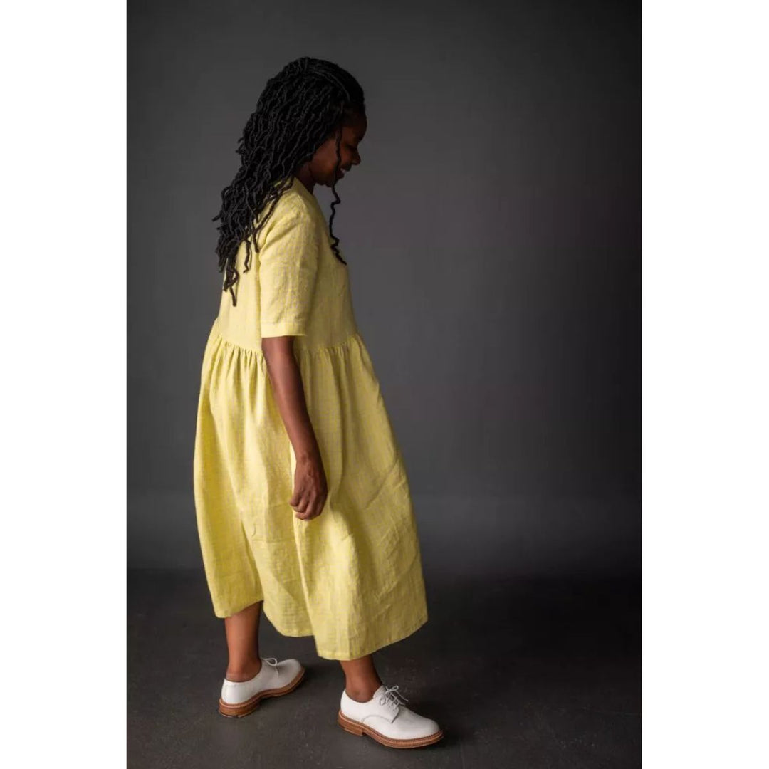 Woman wearing a yellow dress against a dark background