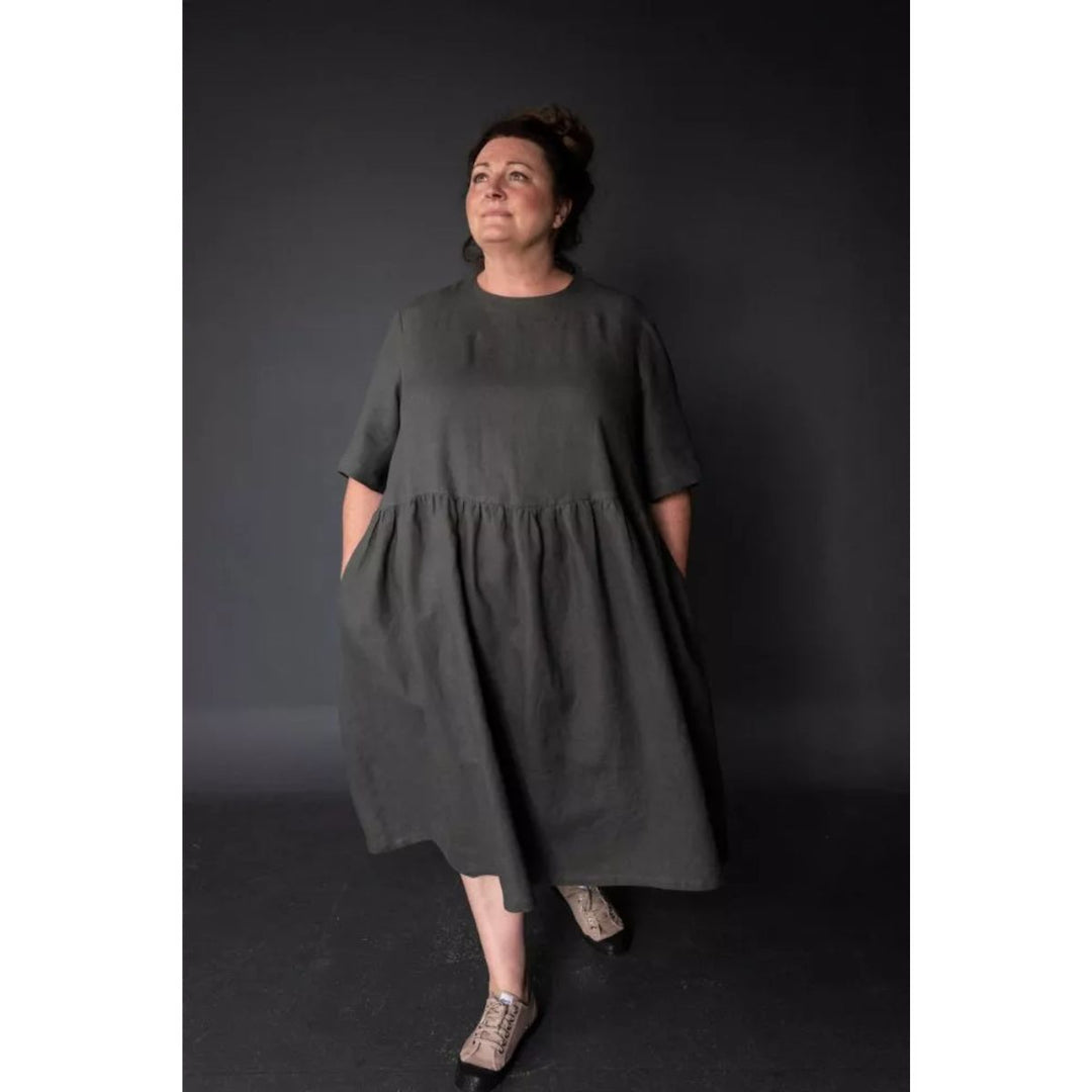 Woman wearing a dark green dress against a black background