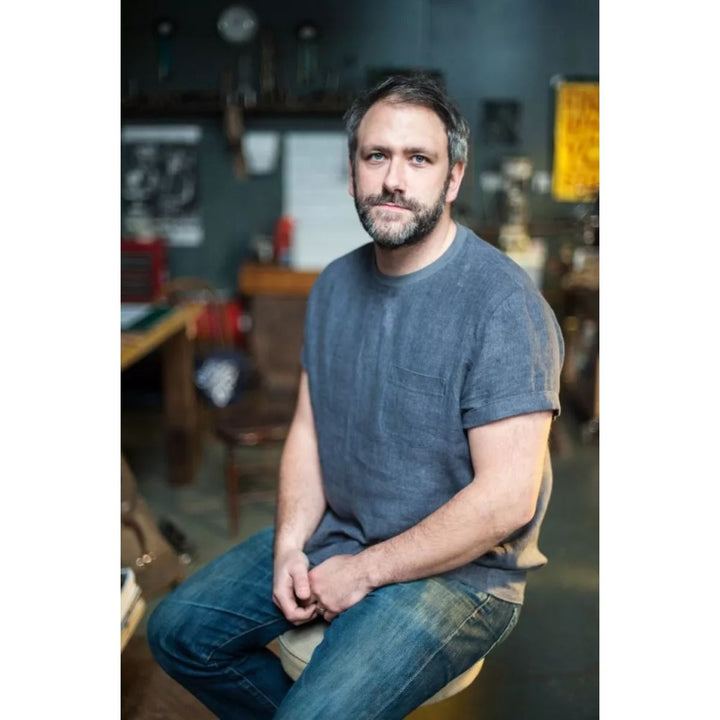 Man sitting in a casual setting with a blurred background