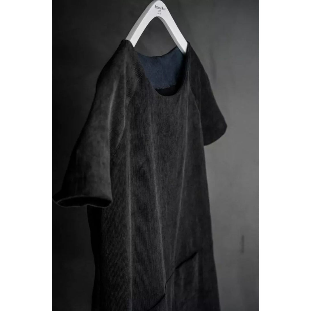 Dark gray t-shirt on a hanger against a dark background