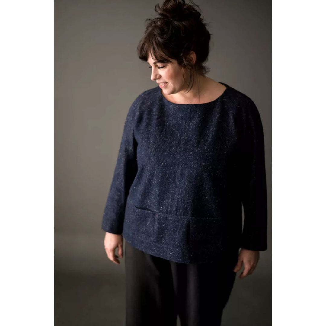 Woman wearing a dark blue sweater against a plain background