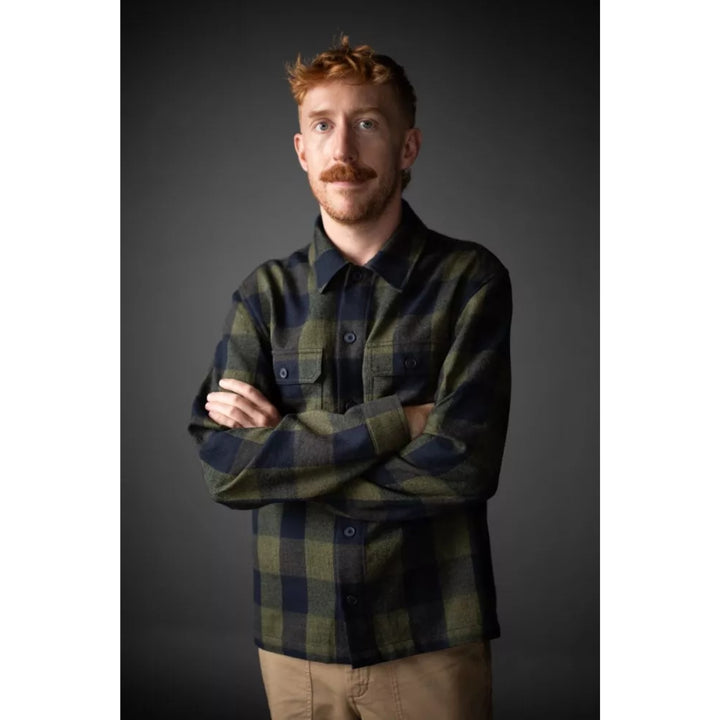 Man wearing a plaid shirt against a dark background