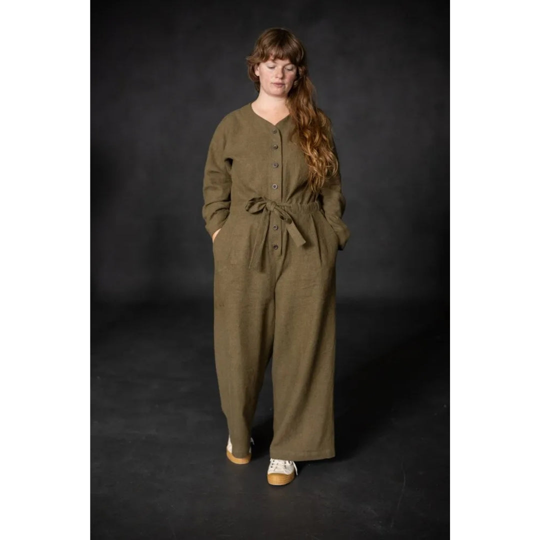 Woman wearing a green jumpsuit against a black background