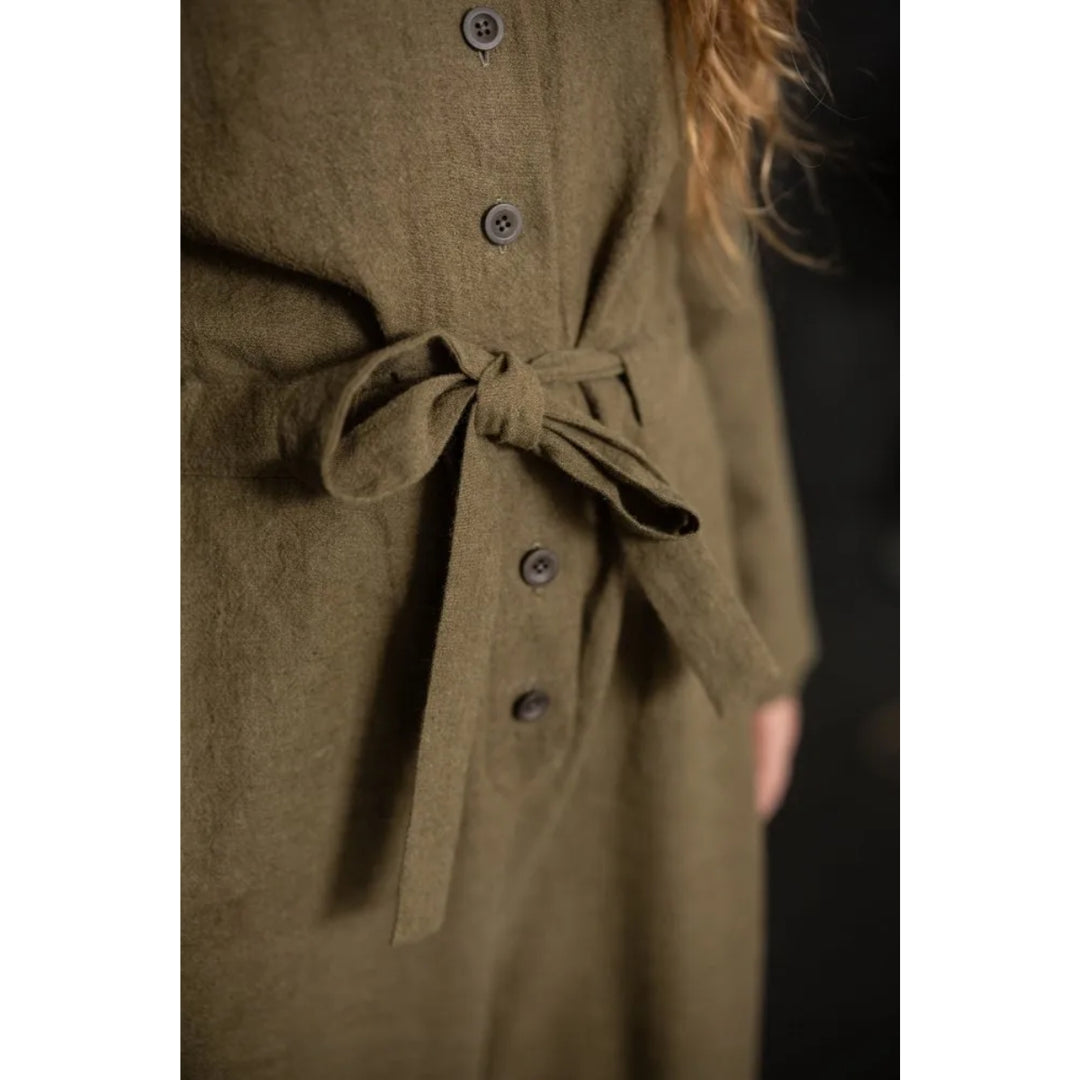 Green coat with buttons and a tie waist on a plain background