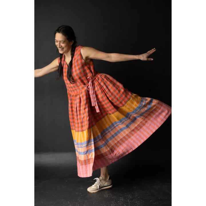 Woman in a colorful dress posing against a black background