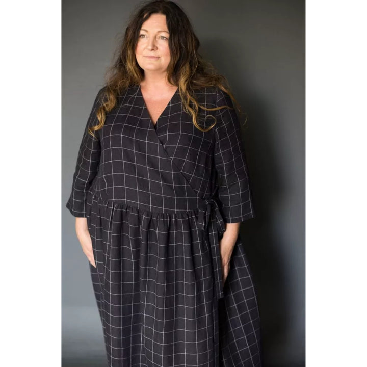 Woman wearing a black checkered dress against a gray background