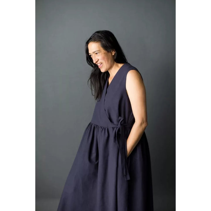 Woman wearing a navy blue dress against a gray background