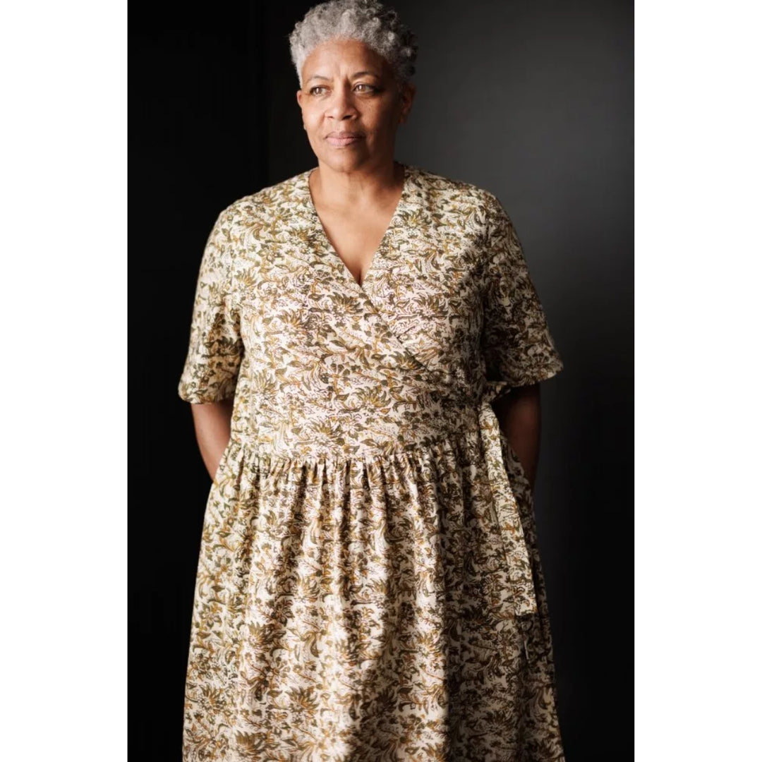 Woman wearing a floral dress against a dark background