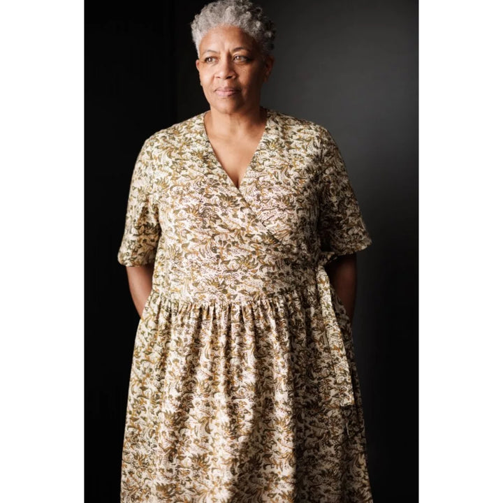 Woman wearing a floral dress against a dark background