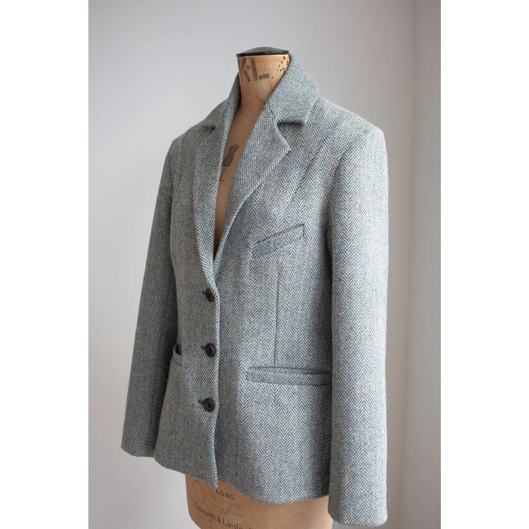 Gray blazer on a mannequin against a plain background