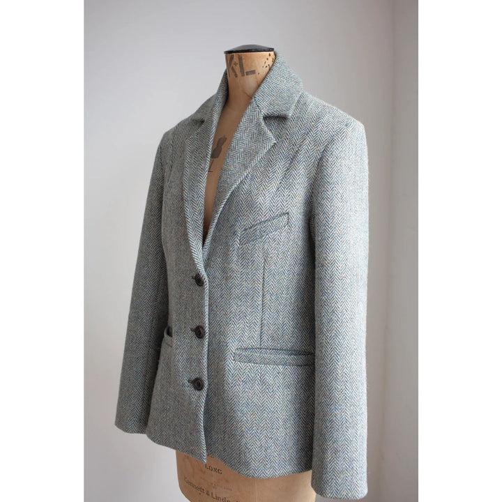 Gray blazer on a mannequin against a plain background