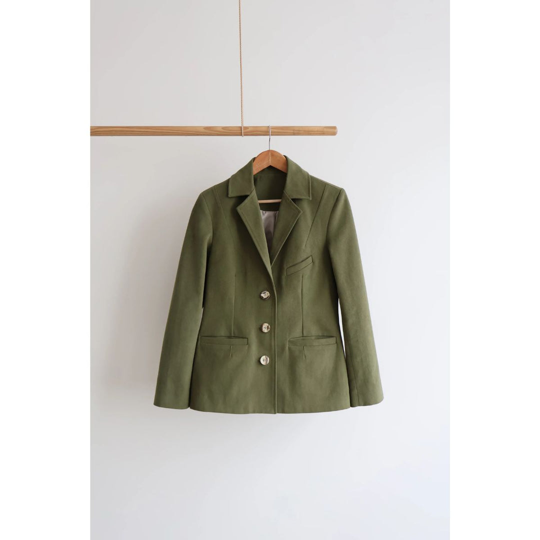 Green jacket on a hanger against a white background
