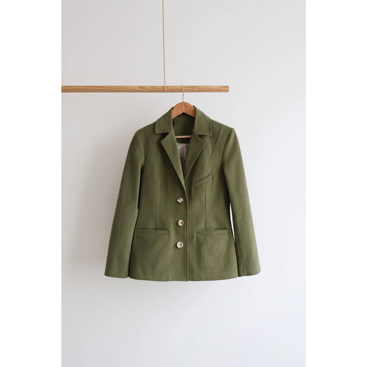 Green jacket on a hanger against a white background