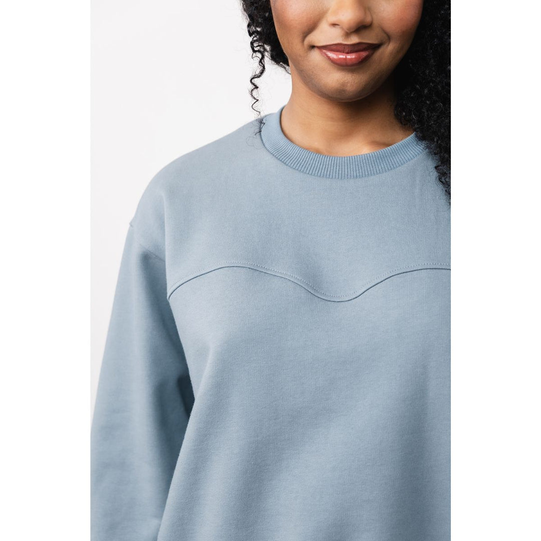 Light blue sweater worn by a person on a white background