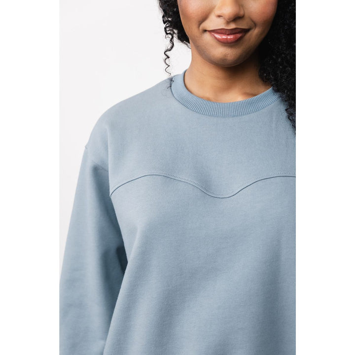 Light blue sweater worn by a person on a white background