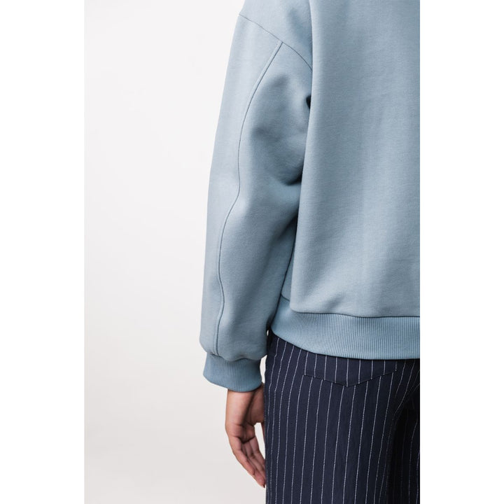 Light blue sweatshirt worn by a person on a white background
