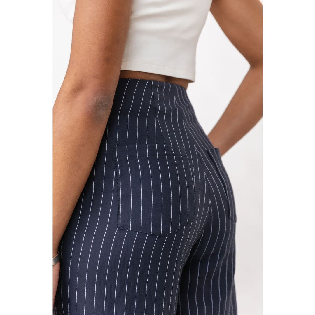 Navy pinstripe pants worn by a person on a white background