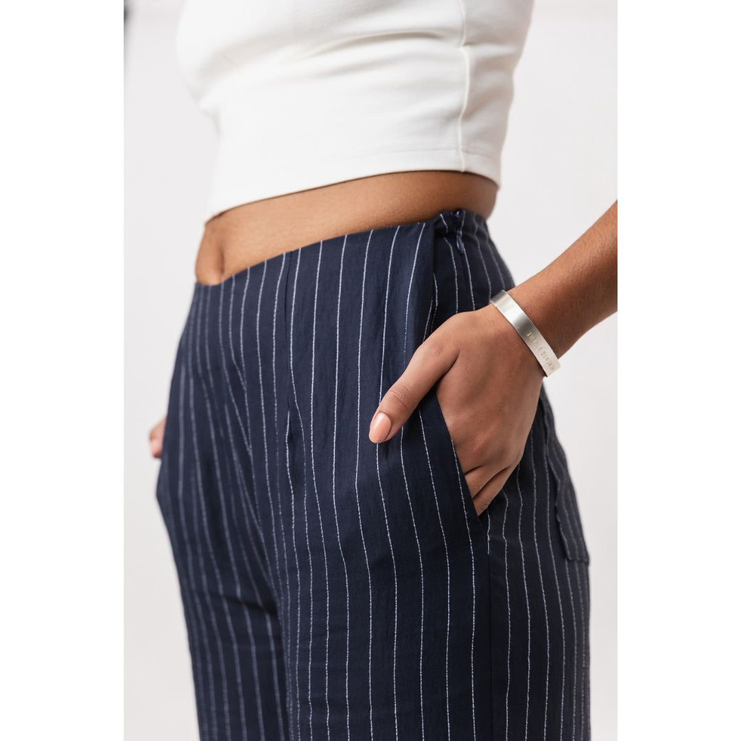 Navy pinstripe pants worn by a person on a white background
