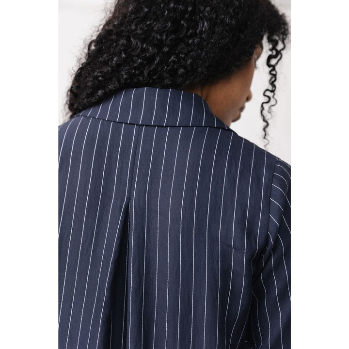 Navy pinstripe shirt worn by a person with a white background