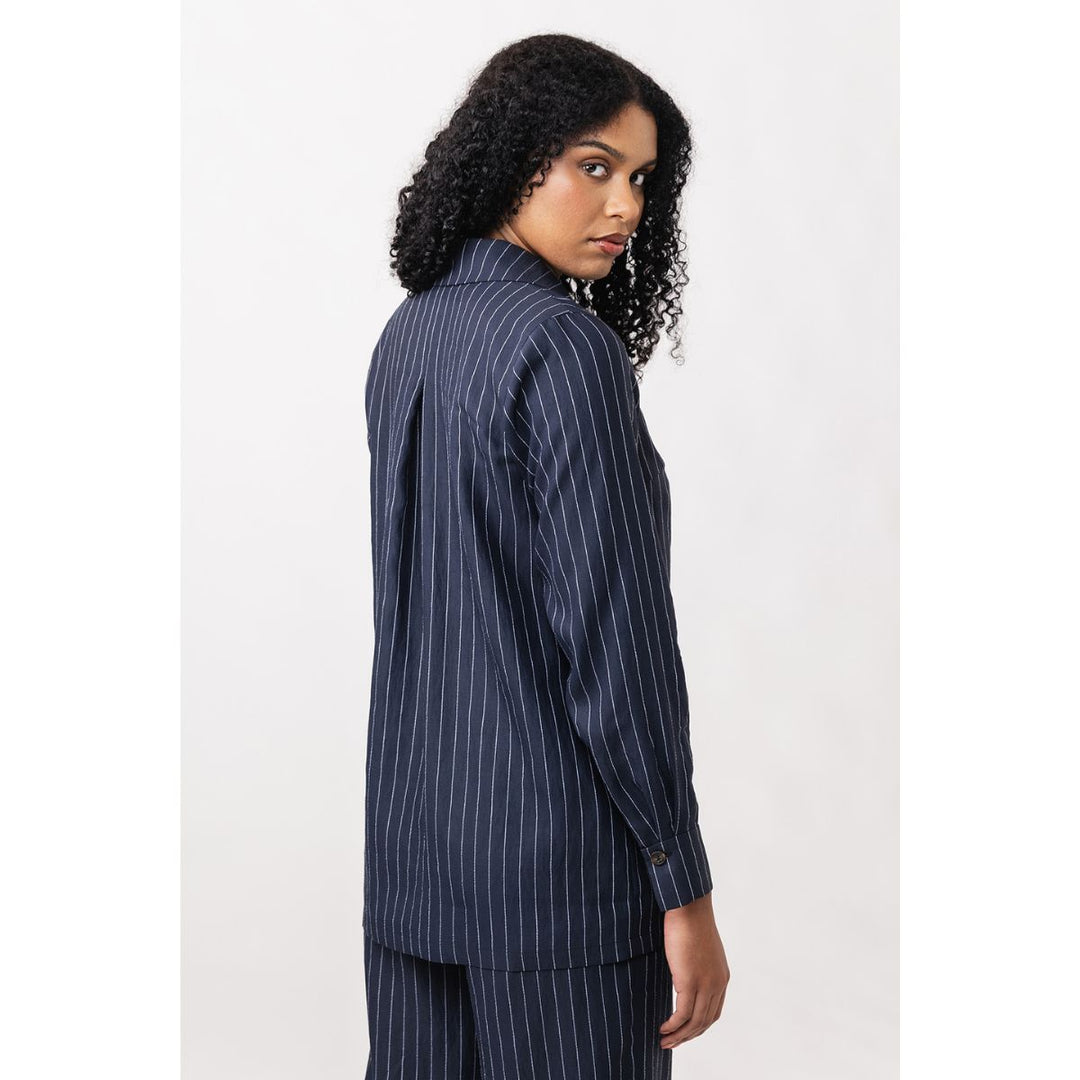 Woman wearing a navy pinstripe shirt on a white background