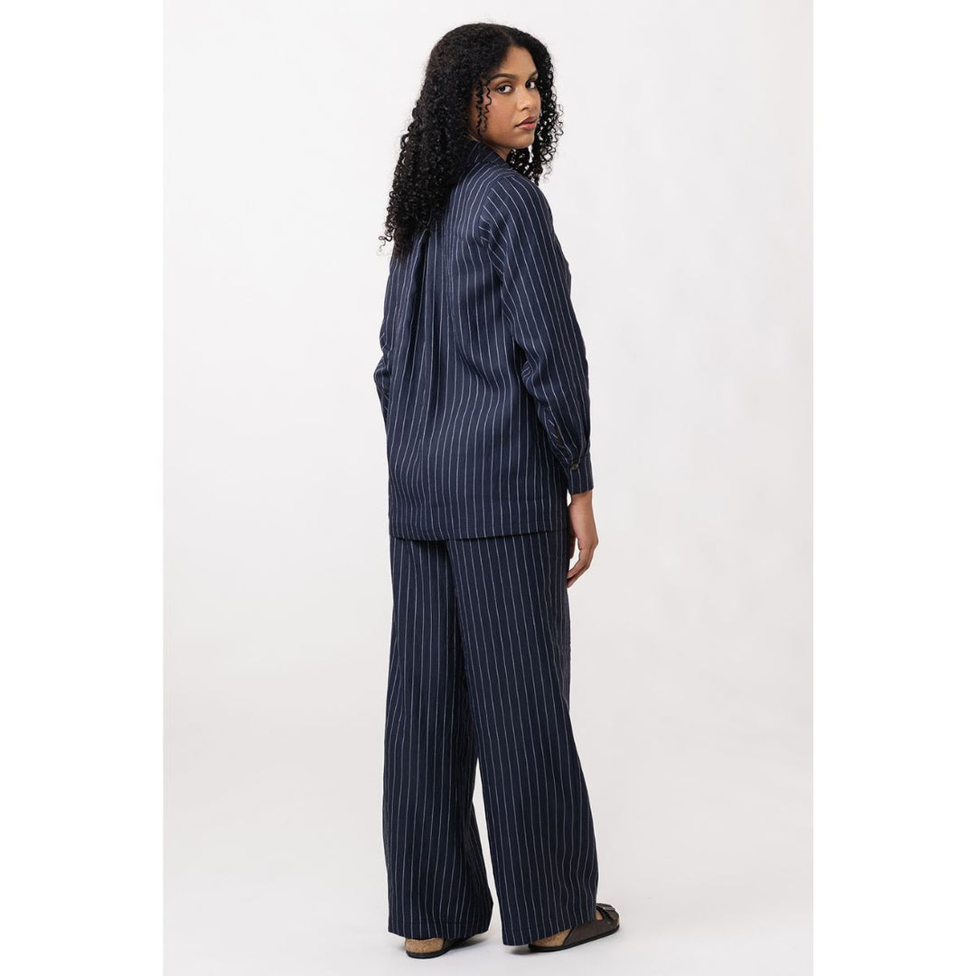 Woman wearing a navy pinstripe suit on a white background