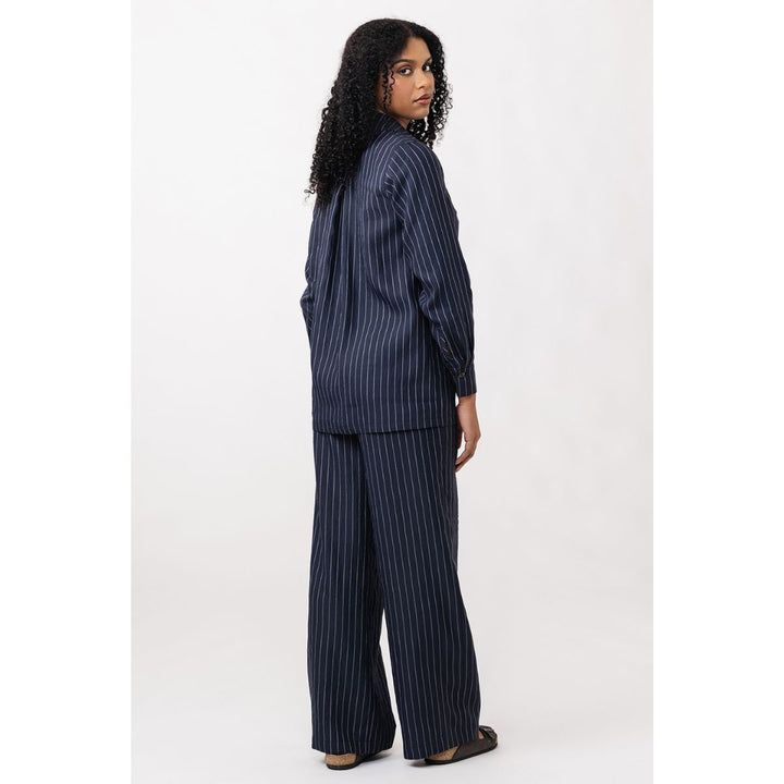 Woman wearing a navy pinstripe suit on a white background