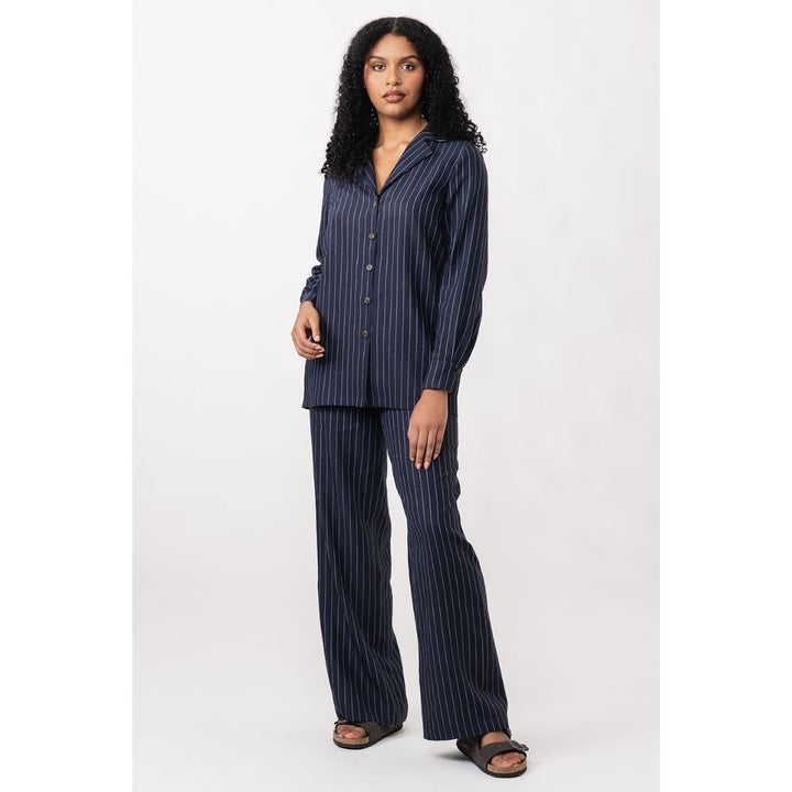 Woman wearing a navy pinstripe shirt on a white background