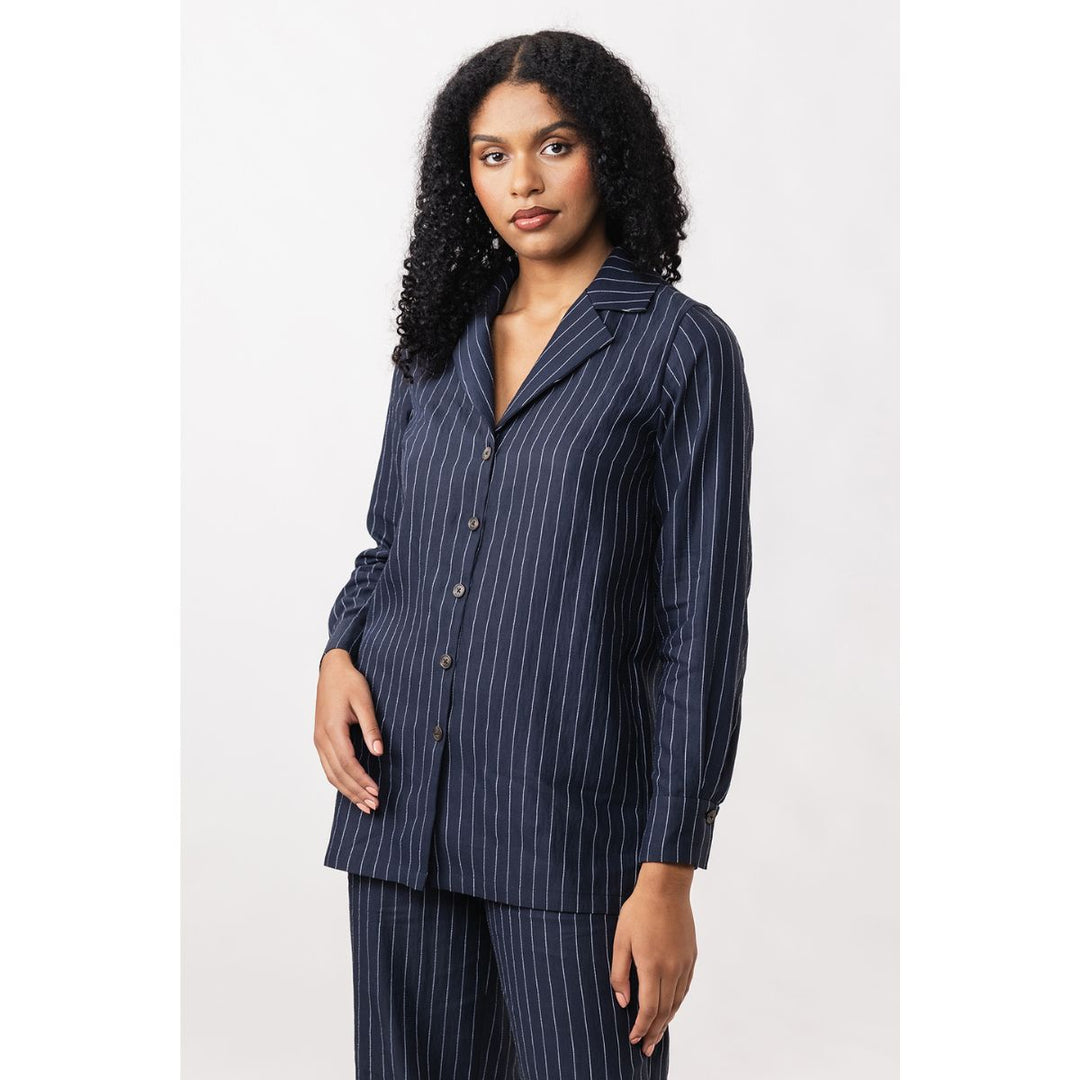 Woman wearing a navy pinstripe shirt on a white background